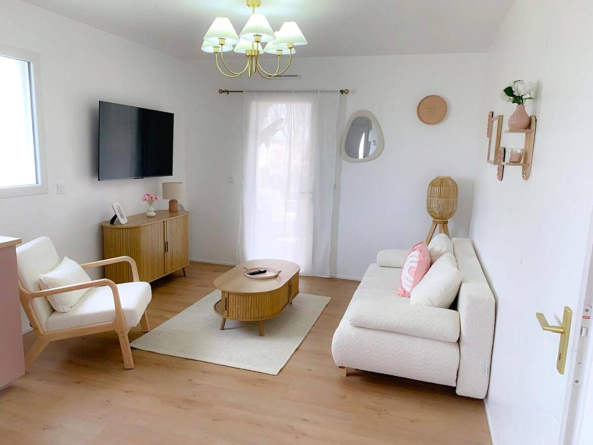 Salon moderne avec canapé blanc et télévision - Le Cocon Rose Jacuzzi privé rêve et Douceur