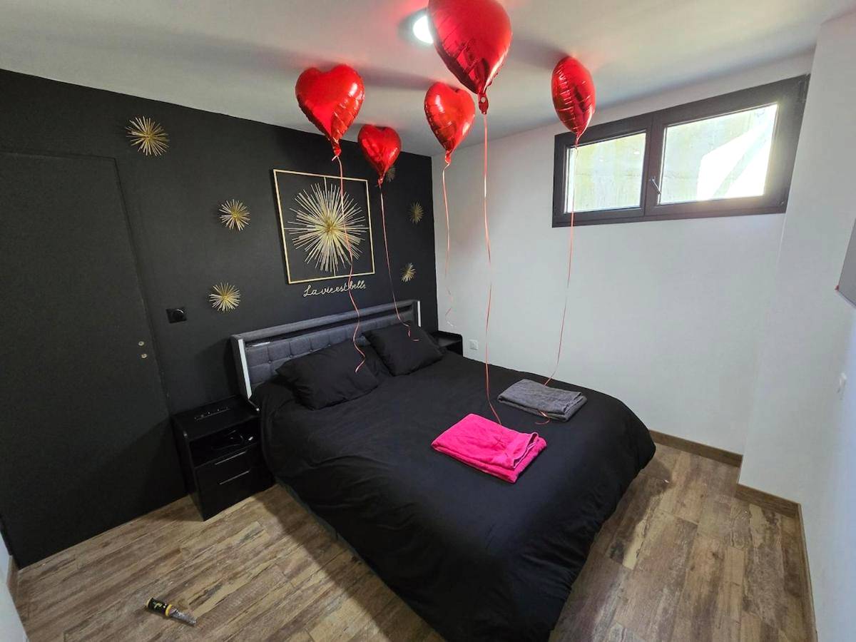 Chambre avec ballons en cœur et mur noir - Cocon Spa & Cinema Room
