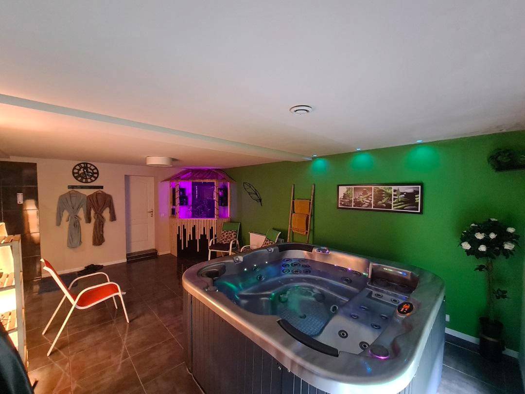 Espace bien - être avec jacuzzi et mur vert - Le Cocon - Gite Spa et Sauna privatif en Centre Alsace