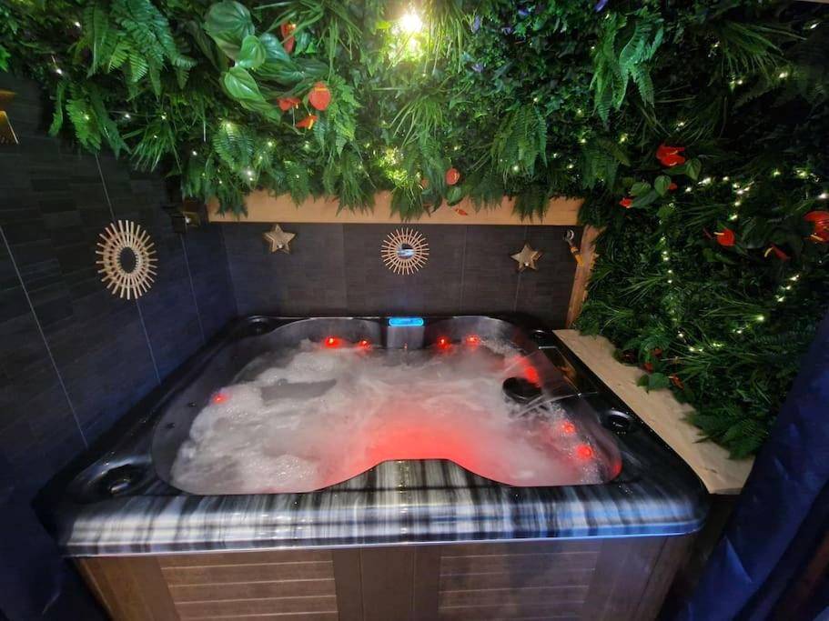 Jacuzzi privatif avec éclairage rouge et verdure - Love Room Mieussy - Cocon tout confort spa privatif