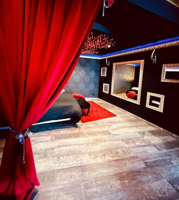 Chambre thématique avec miroirs et rideau rouge - COCONROOM balneo - sauna La suitE