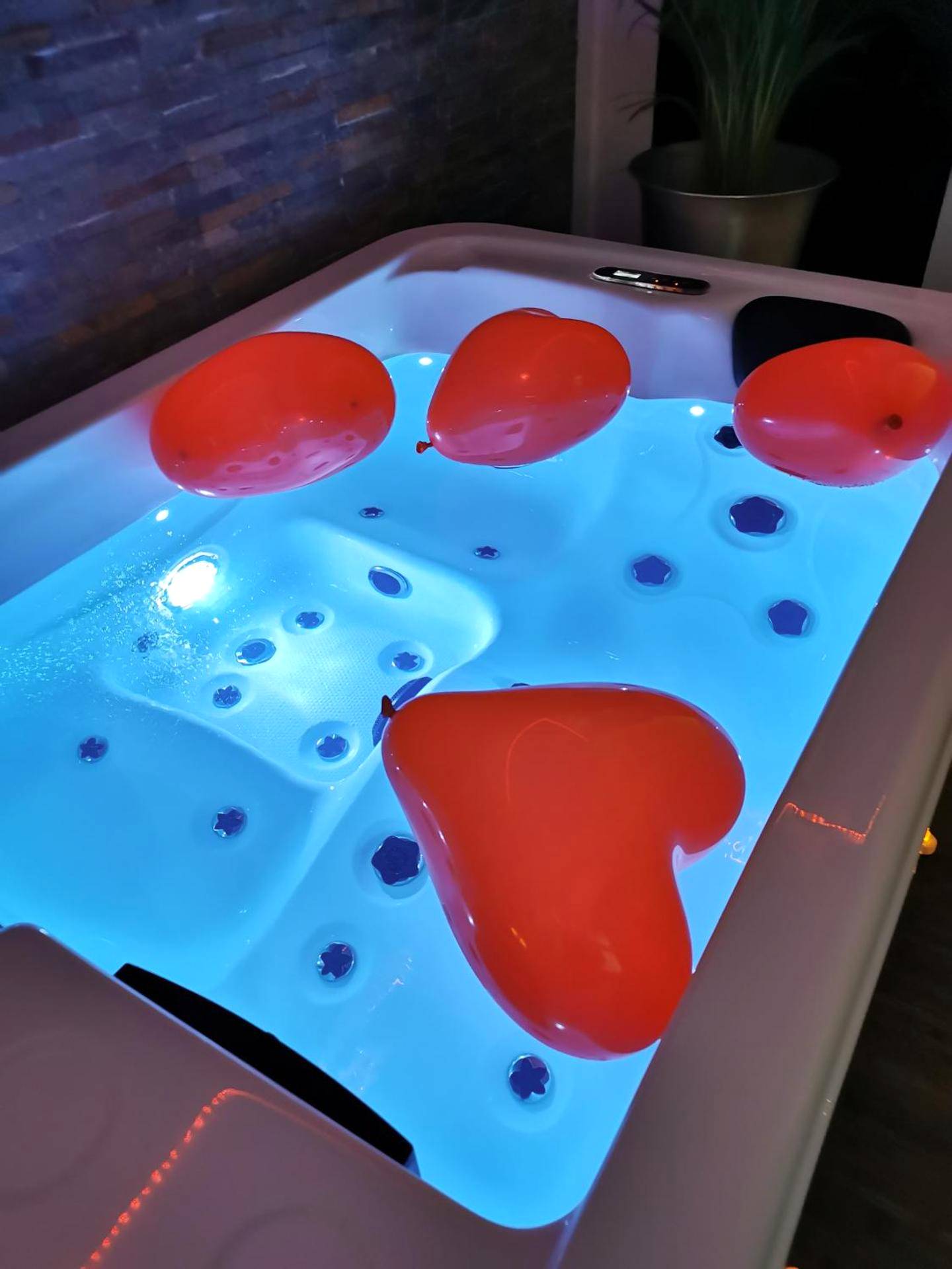 Jacuzzi éclairé en bleu avec ballons en cœur - Cocoon d'Allauch