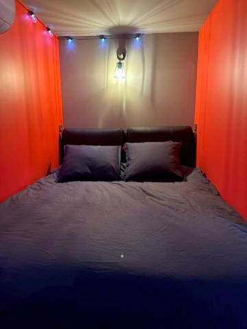 Lit double dans alcôve aux tons rouges - Love Room Cocooning & Spa