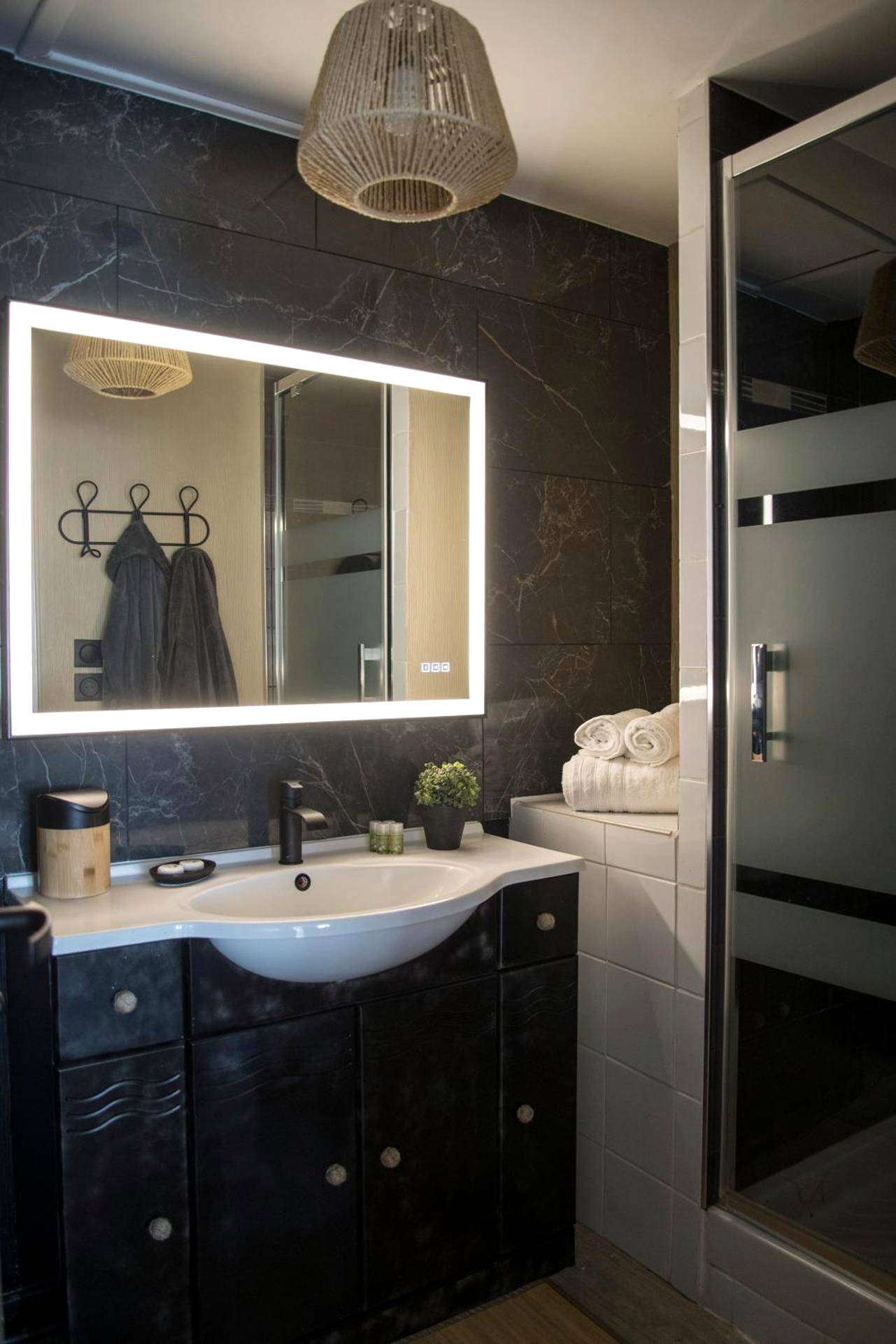Salle de bain avec miroir LED et vasque noire - COCOONING SPA - Gîte avec piscine, jacuzzi, sauna
