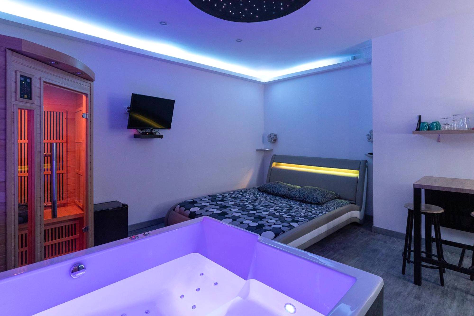 Jacuzzi au premier plan et sauna en bois - Cocooning Spa