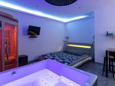 Jacuzzi au premier plan et sauna en bois - Cocooning Spa