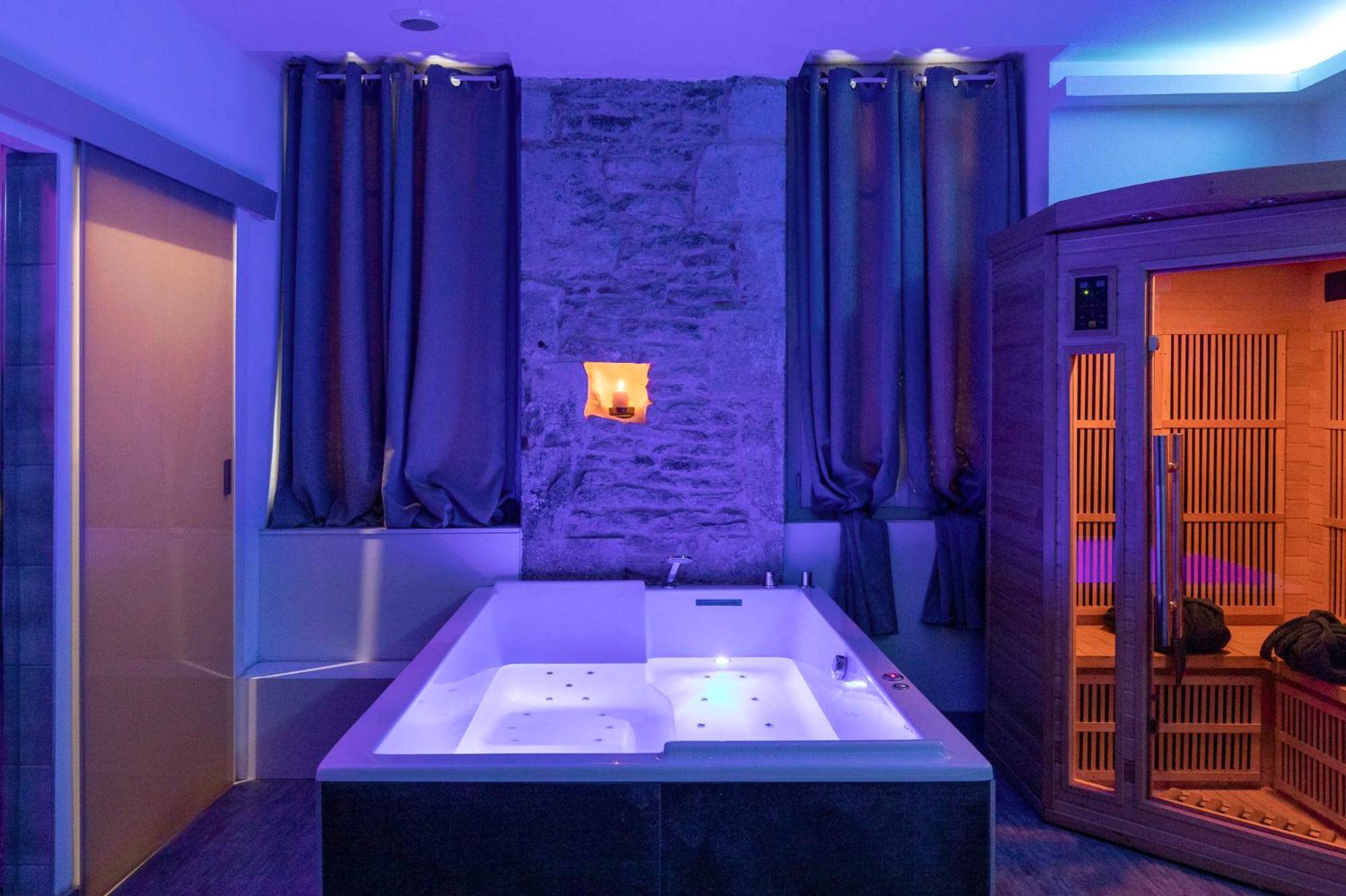 Jacuzzi privatif devant un mur en pierre - Cocooning Spa