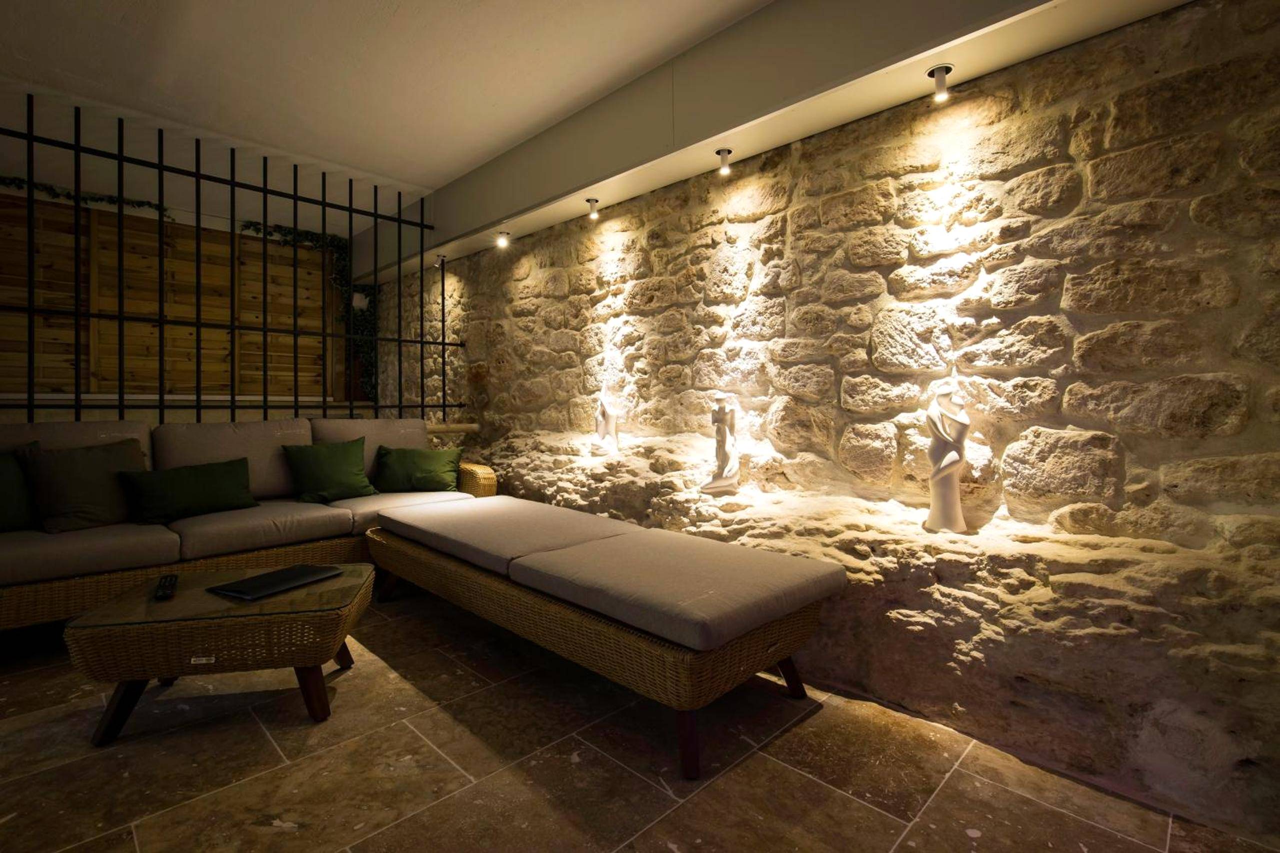 Salon de détente avec mur en pierre éclairé - Love Room centre ville de Cognac