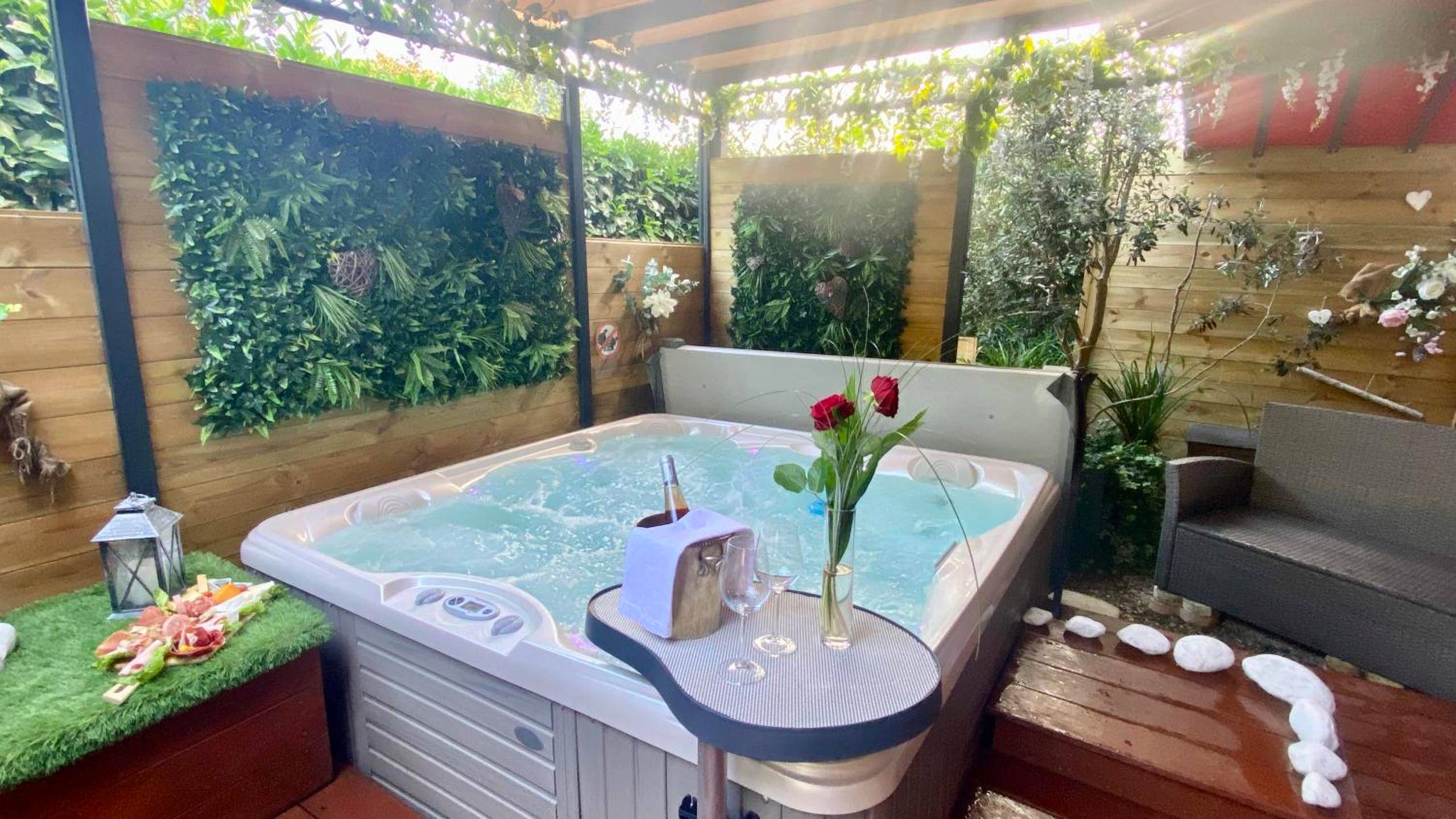 Jacuzzi extérieur sous pergola avec roses - Love Room Toulouse - Un petit coin de Paradis