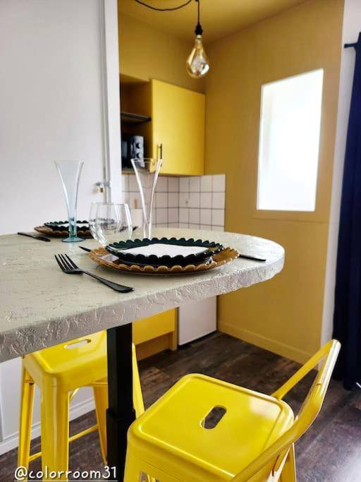 Espace repas avec chaises jaunes et table dressée - Colorroom31 - Nuit insolite - Spa - Tantra - Love room