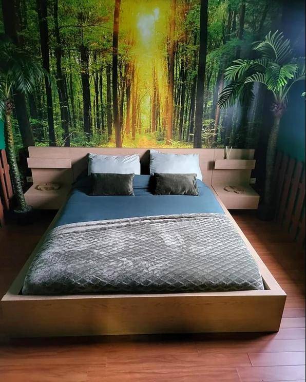 Lit double devant une fresque de forêt - Coquéo Spa & Sauna Suite Paris Disneyland