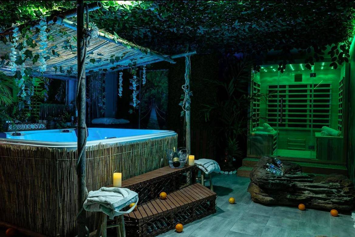 Jacuzzi illuminé et sauna dans un décor végétal - Coquéo Spa & Sauna Suite Paris Disneyland