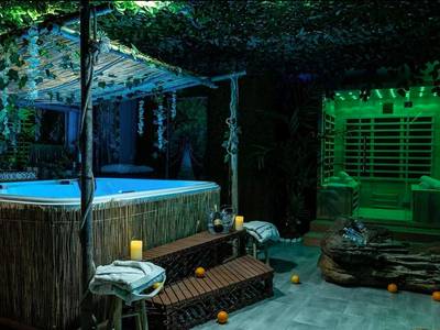 Jacuzzi illuminé et sauna dans un décor végétal - Coquéo Spa & Sauna Suite Paris Disneyland