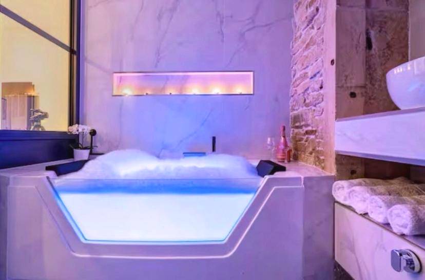 Jacuzzi privatif avec paroi vitrée et bougies - Cosy Love