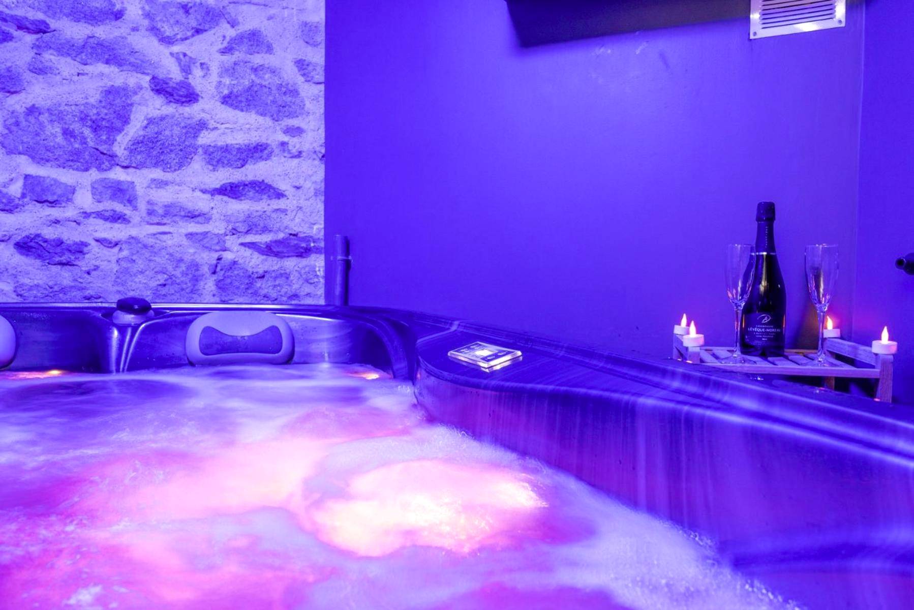 Jacuzzi avec bouteille et éclairage tamisé - Love Room Nantes - Cosy Room Jacuzzi Romantique