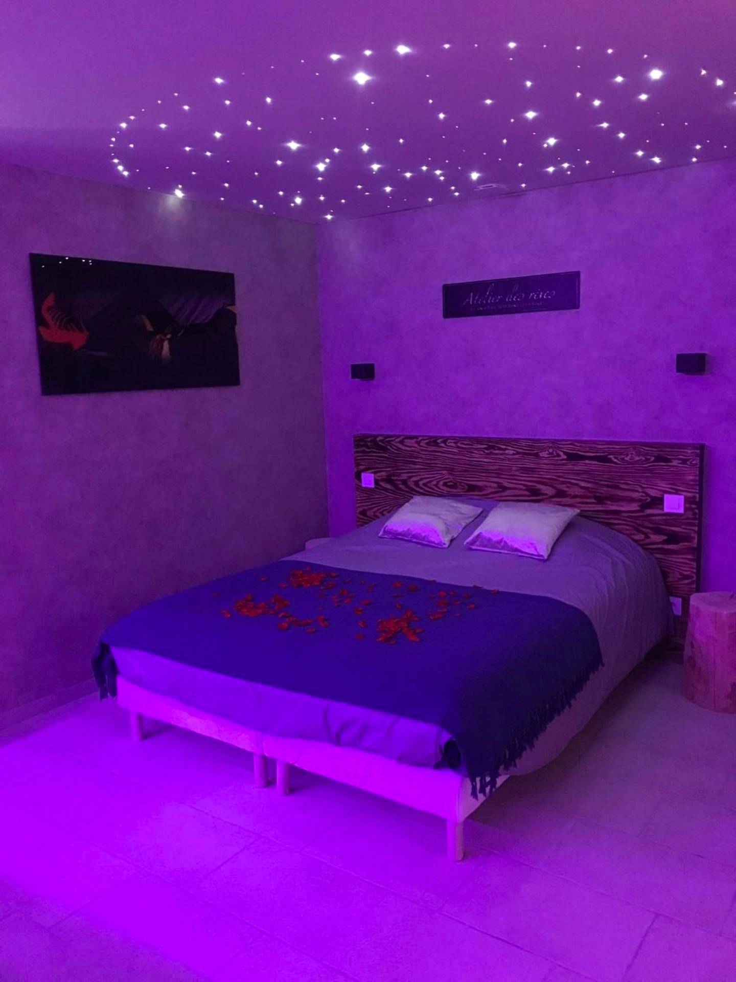 Lit double sous un plafond ciel étoilé - Cosy Love & Spa Love room avec spa, hammam et sauna privatif