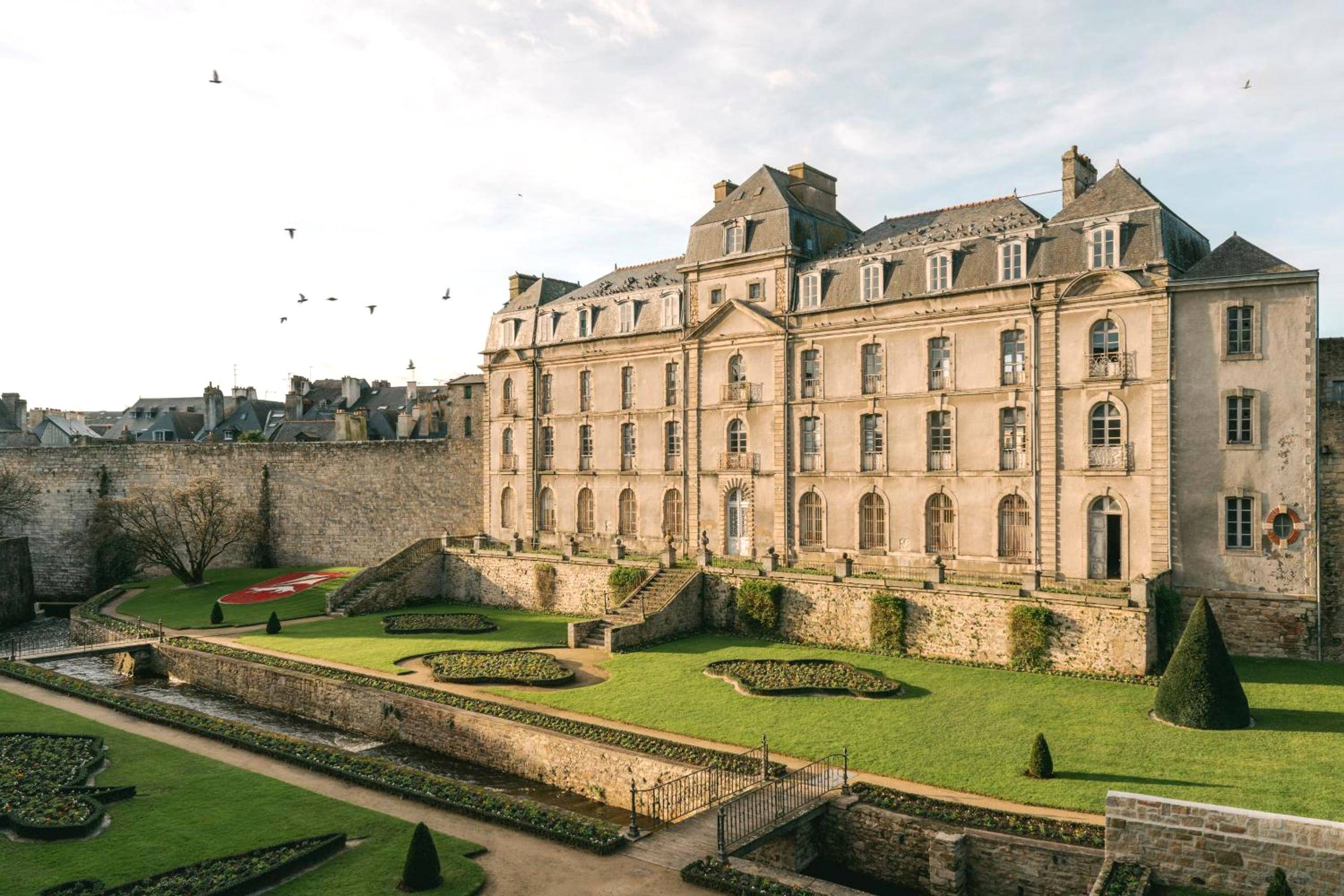 Vue extérieure du bâtiment historique et jardins - LoveRoom Le Côté Secret