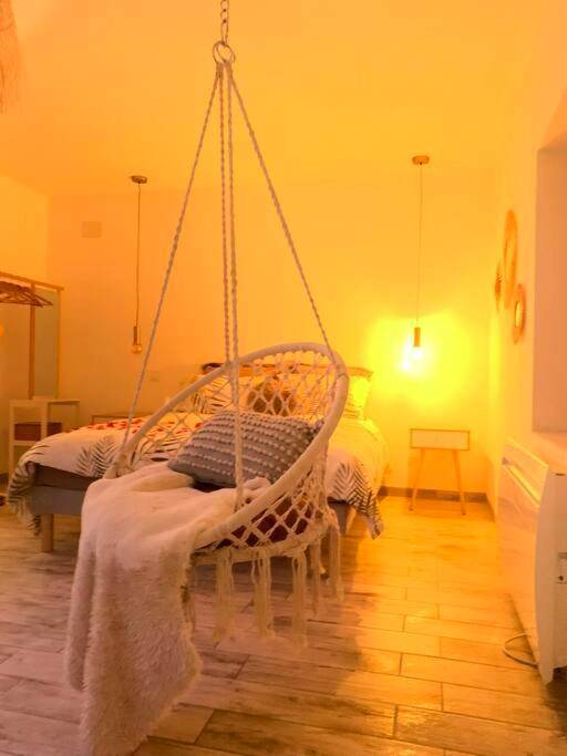 Fauteuil suspendu en macramé et lit double - Cottage Interieur Spa classé 4 étoiles - balnéo et sauna privatif