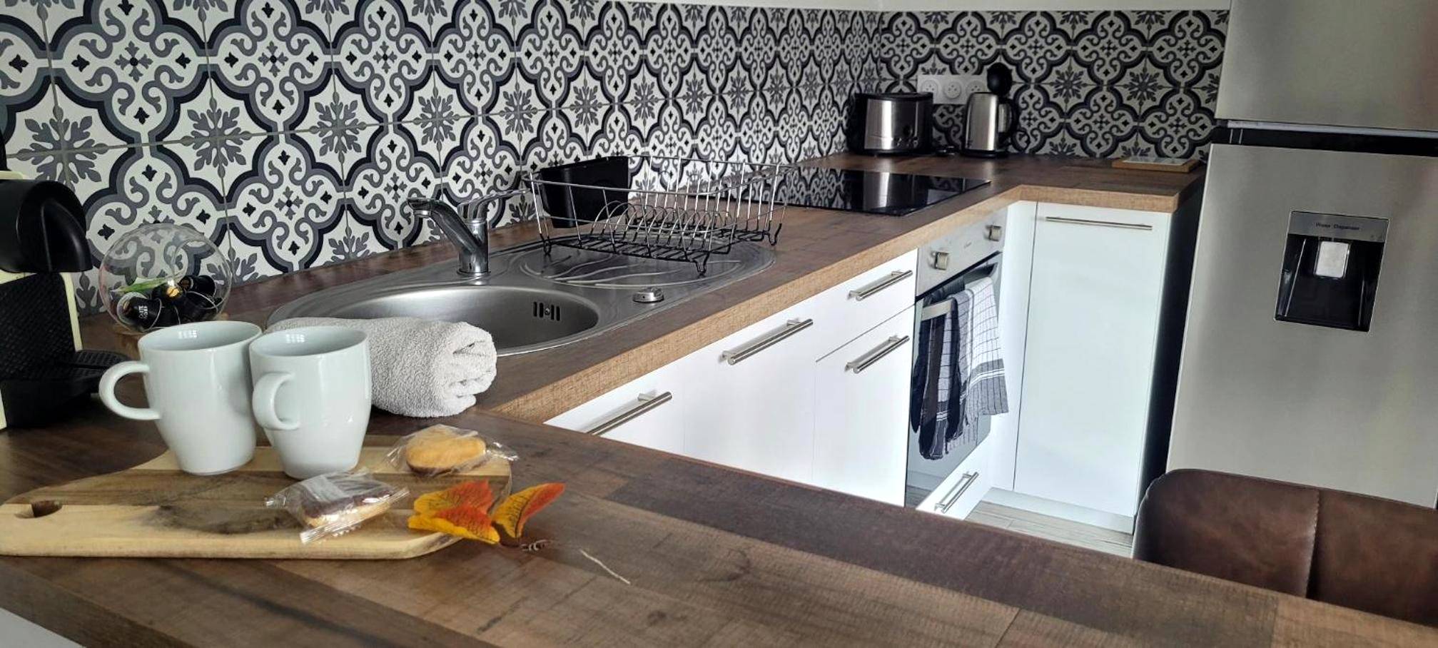 Cuisine équipée avec crédence à motifs - Cottage Interieur Spa classé 4 étoiles - balnéo et sauna privatif