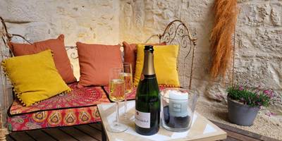 Bouteille de champagne et flûtes en terrasse - Les Coups de Coeur du Quercy