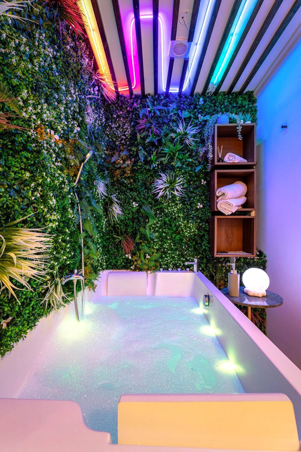 Baignoire balnéo sous néons et mur végétal - Cozy Jacuzzi Bordeaux Chartrons