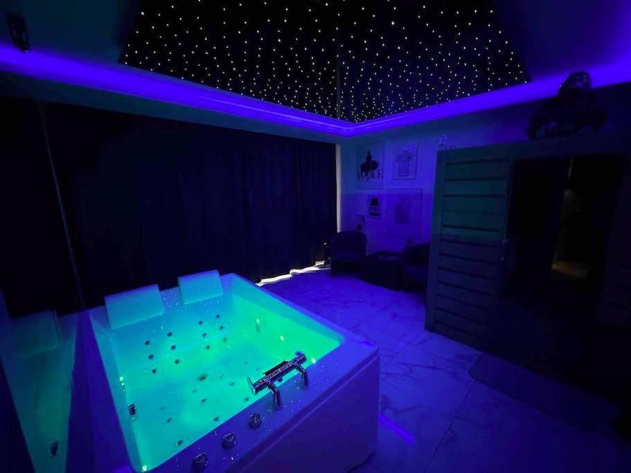 Jacuzzi lumineux sous un ciel étoilé - Cozy Rental SPA