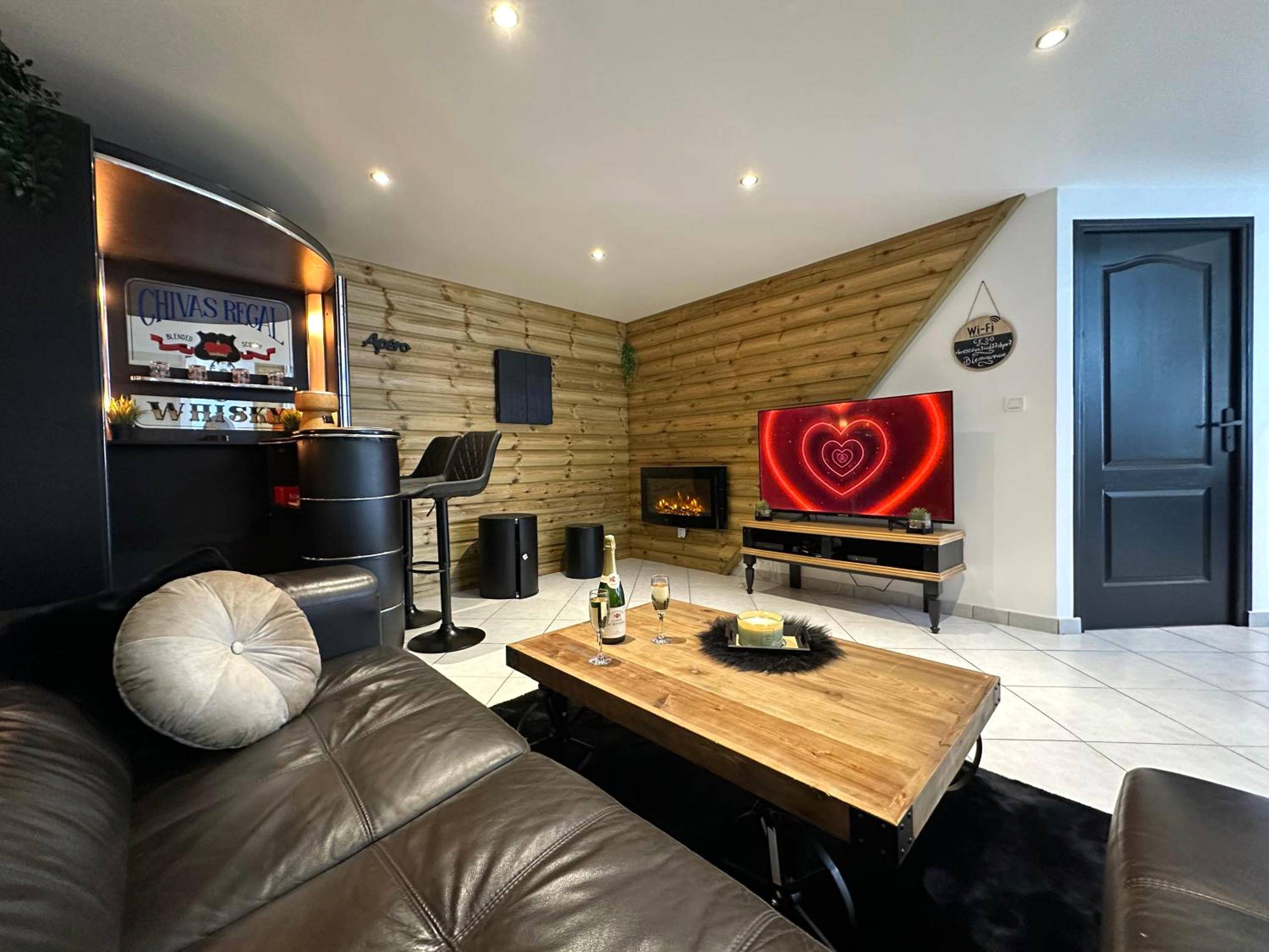 Salon avec cheminée, bar et écran géant - Love Room La Crèche Romantique