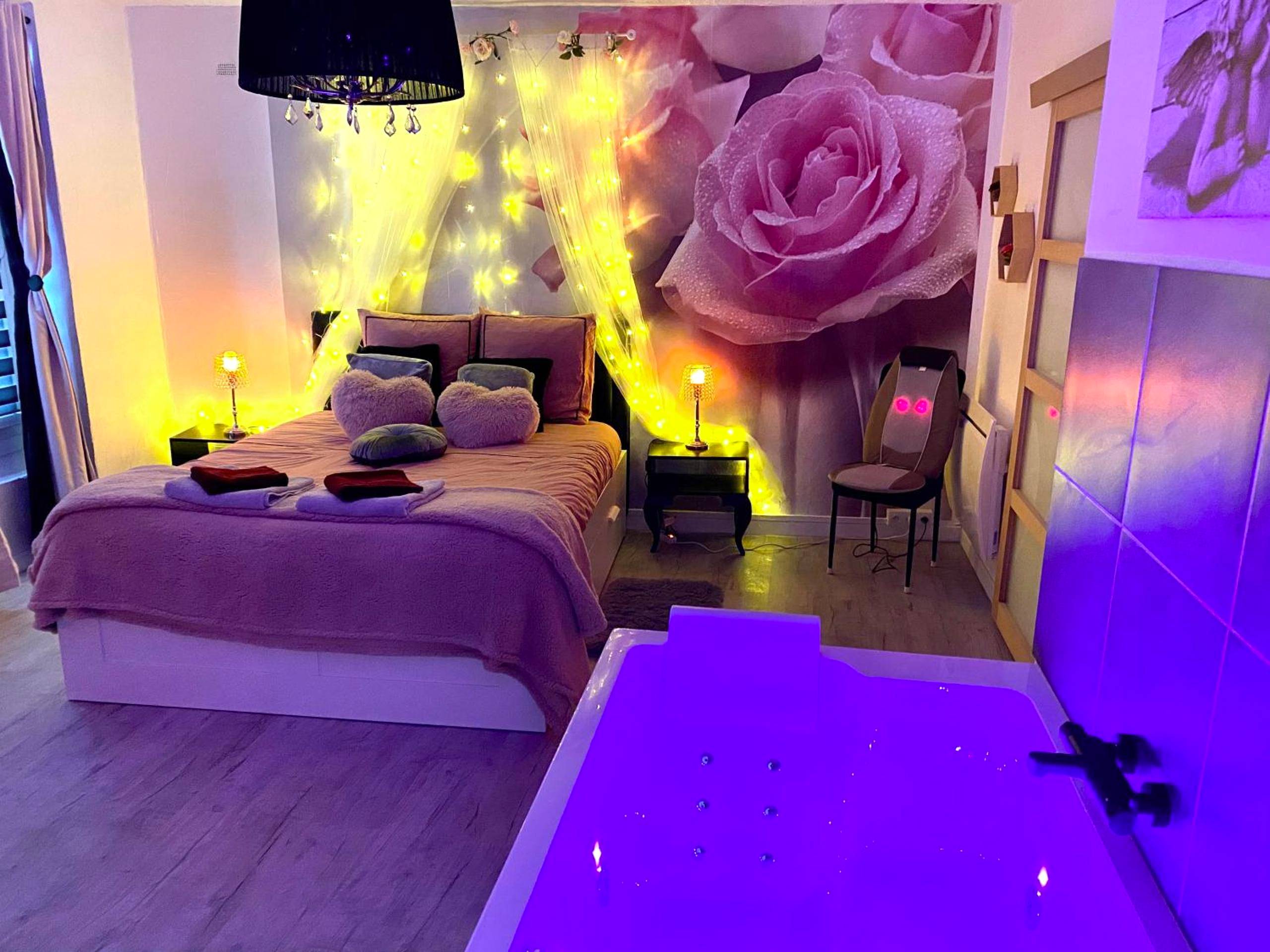 Baignoire balnéo lumineuse face au lit - COSY & SPA Appartement Luxe JACUZZI SAUNA Suite Cristal