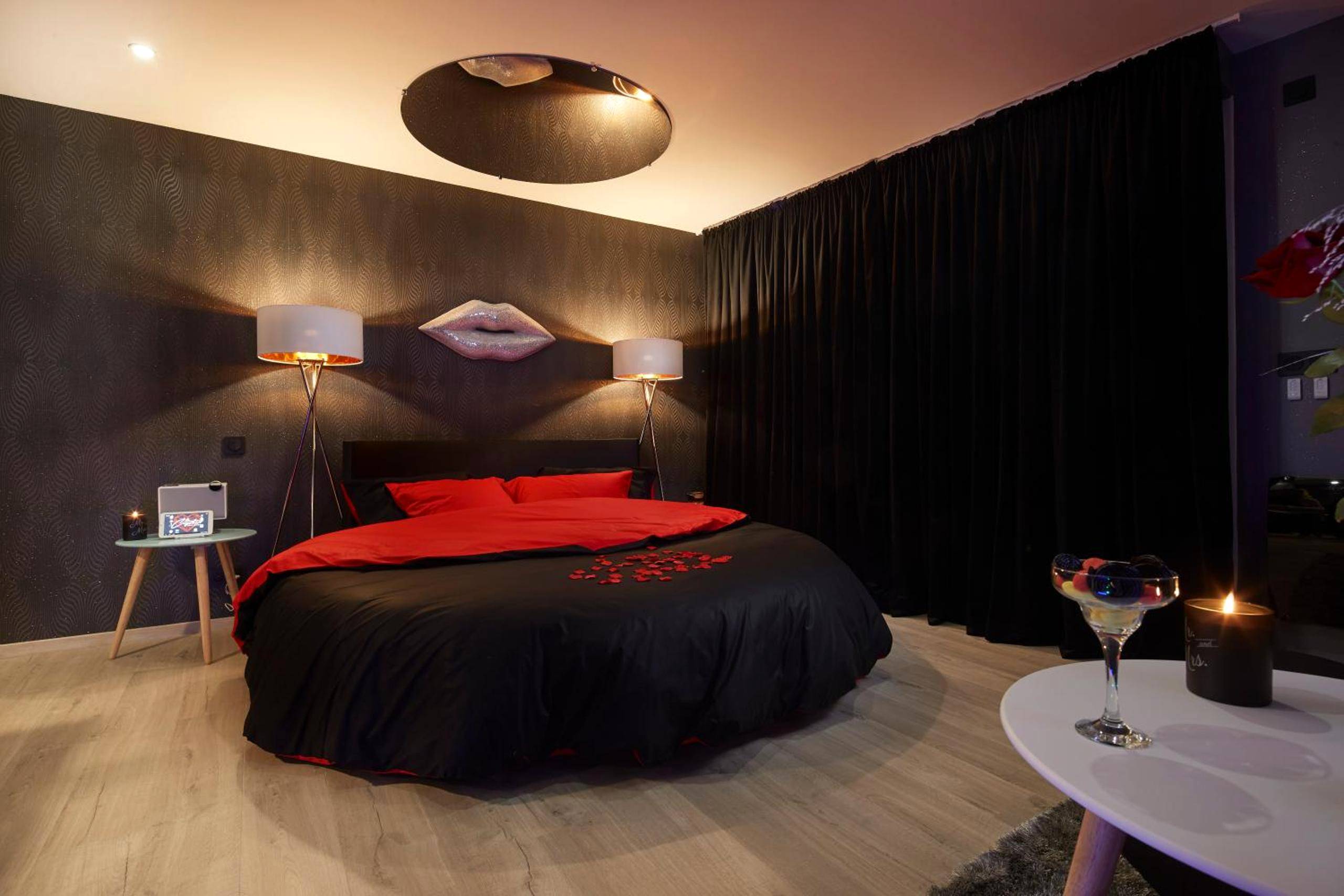 Chambre romantique avec lit rond noir et rouge - Crystal Love Appart