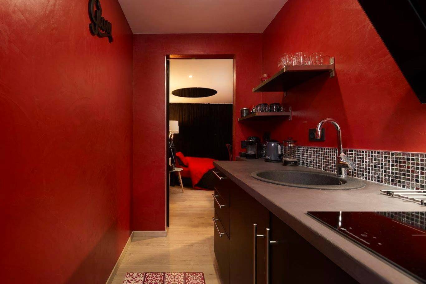Cuisine équipée moderne aux murs rouges - Crystal Love Appart