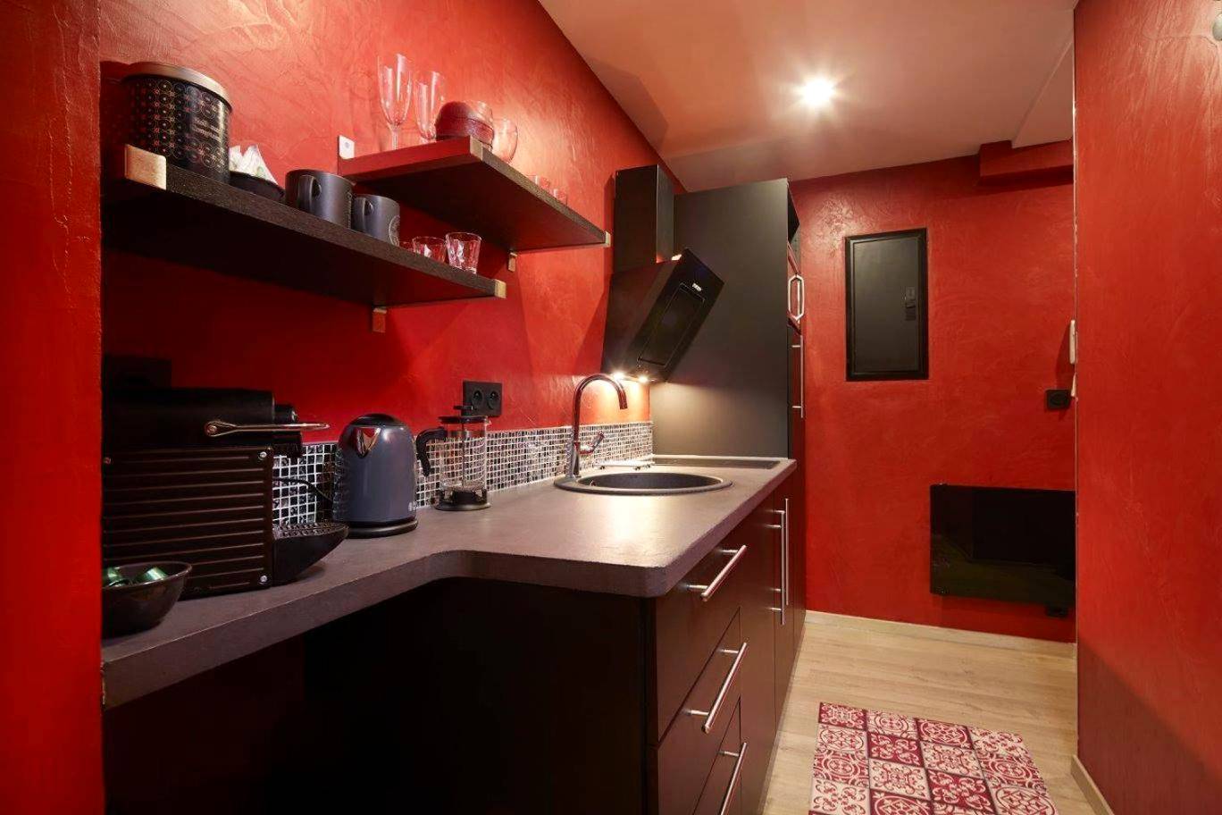 Kitchenette fonctionnelle avec murs rouge vif - Crystal Love Appart