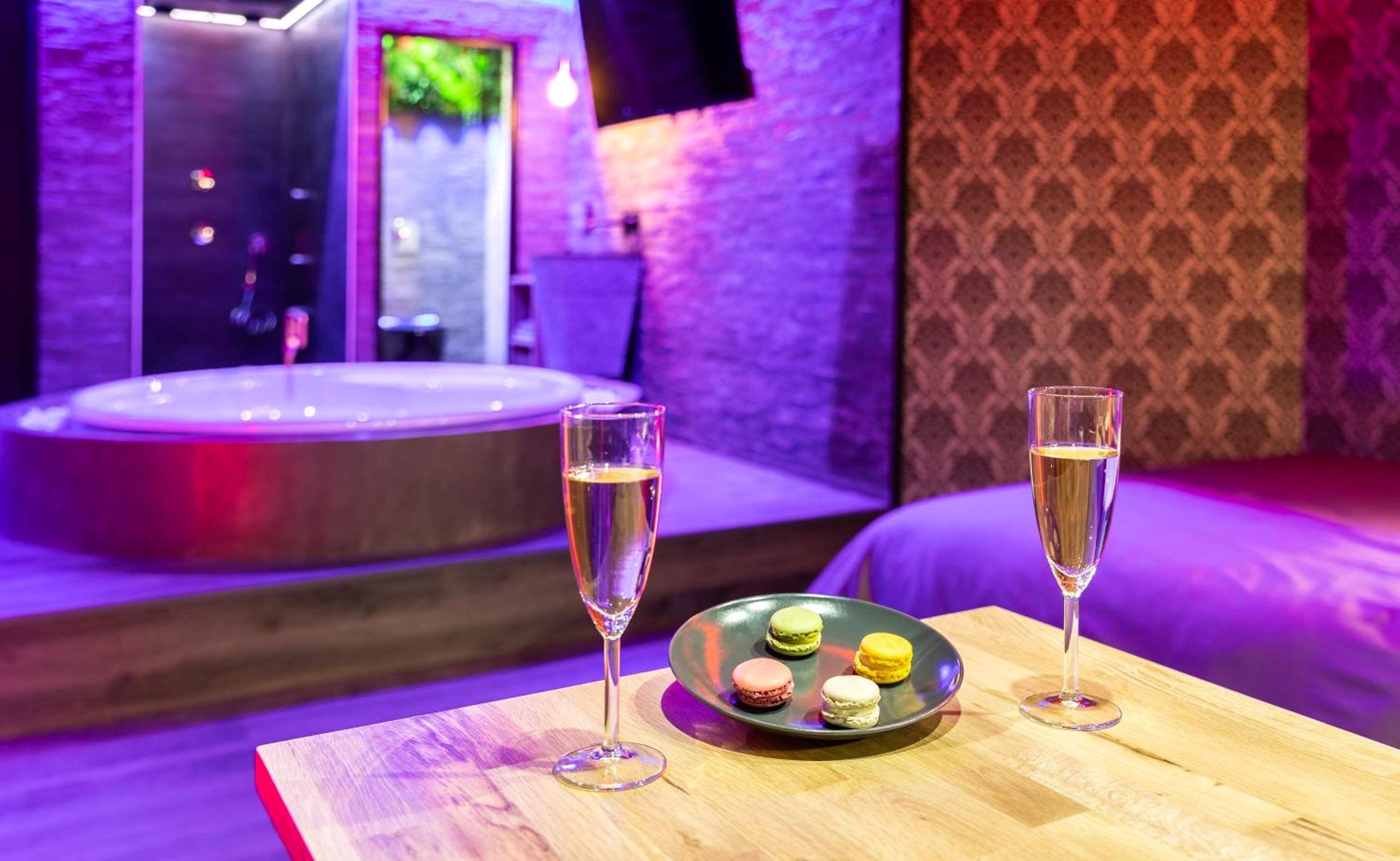 Coupes de champagne et macarons face au jacuzzi - Cupidon Love Room