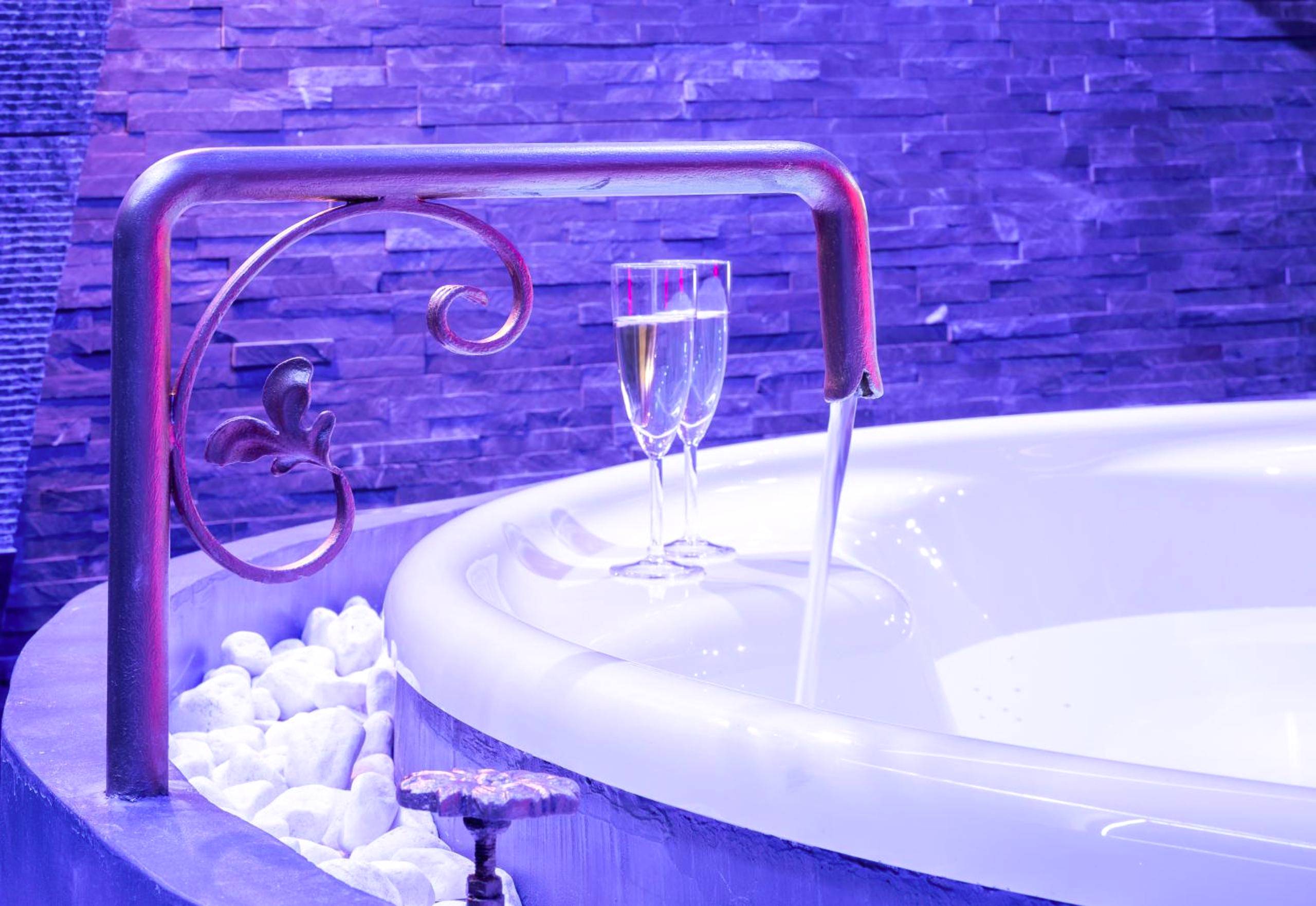 Robinet design versant l'eau dans le jacuzzi - Cupidon Love Room