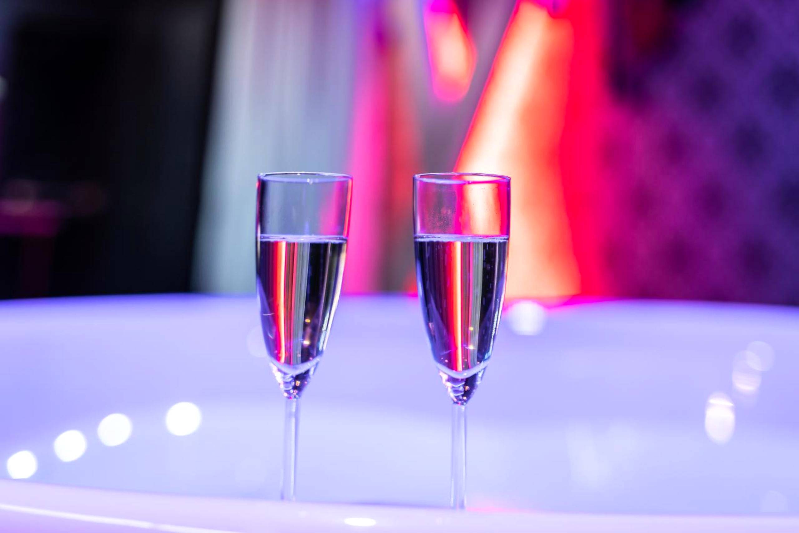 Deux flûtes de champagne au bord du jacuzzi - Cupidon Love Room