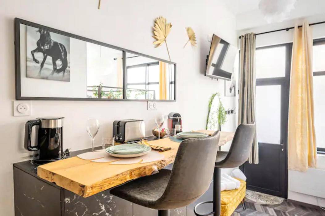 Espace repas avec table en bois brut et tabourets - Le Cupidon, En plein Coeur de Lorient