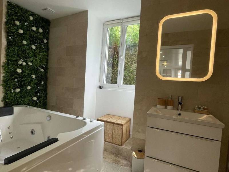 Salle de bain avec jacuzzi et miroir LED - Appartement Dampierre en yvelines