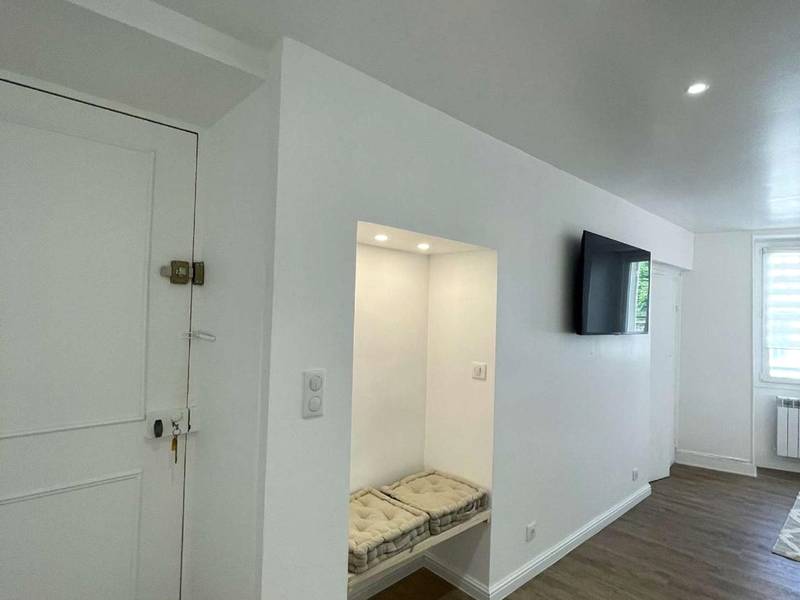 Entrée avec banquette intégrée et télévision - Appartement Dampierre en yvelines