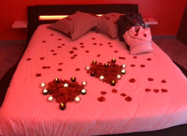 Lit décoré de pétales de rose et bougies - Love Room Dampierre - les - Bois - dampierrelove