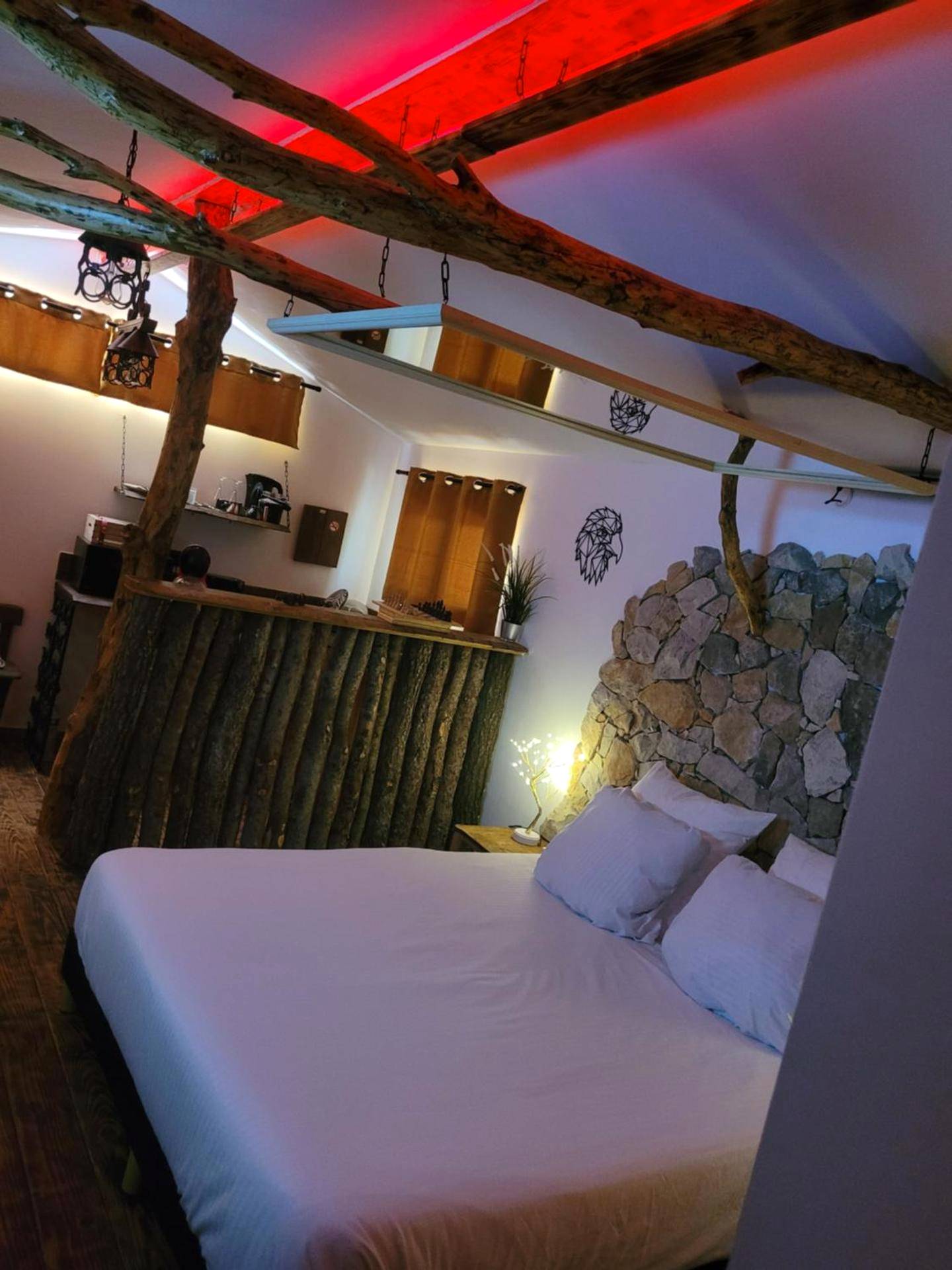 Lit double sous poutres en bois et miroir - LOVE Room Danslesbois avec spa