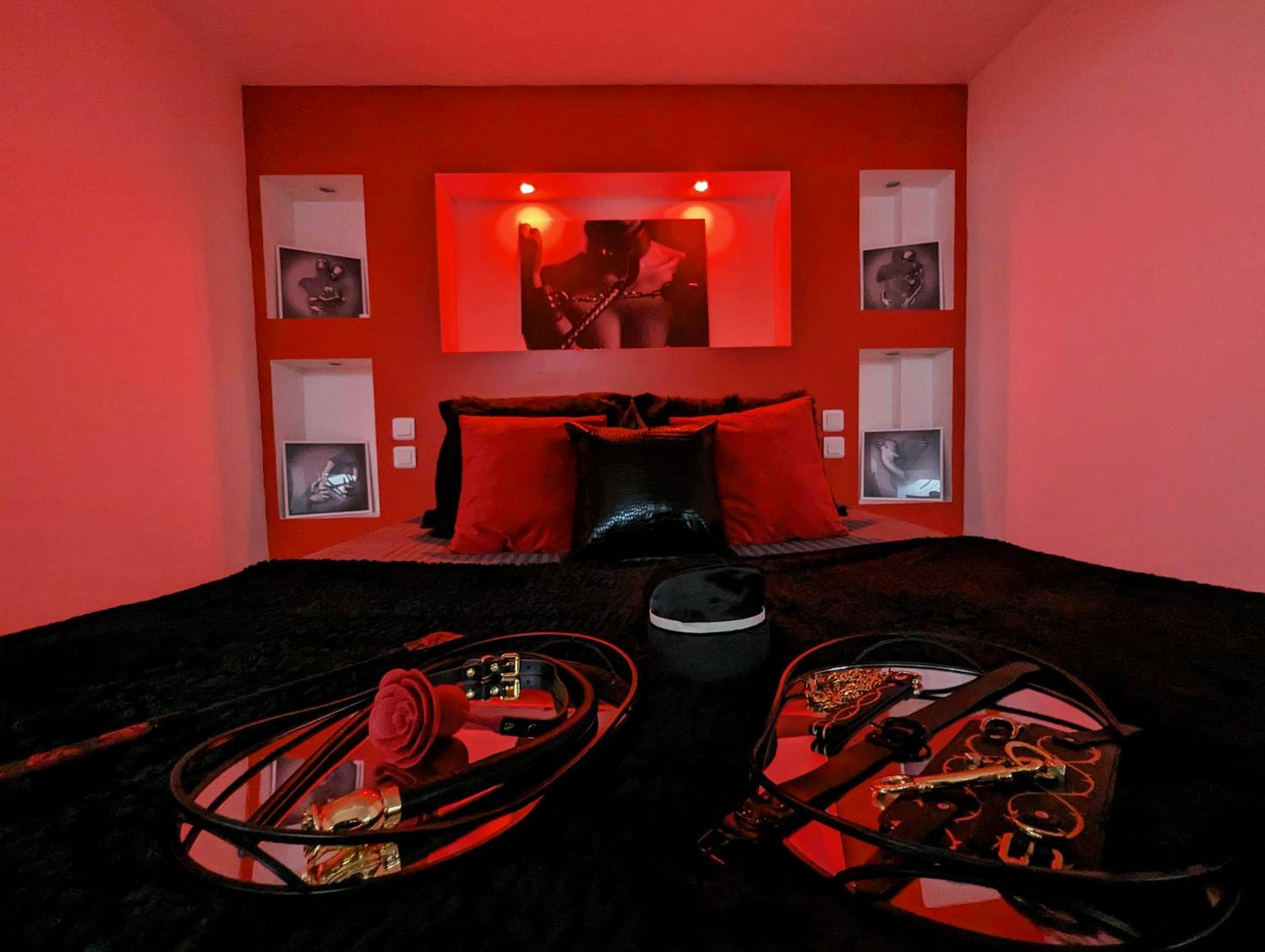 Accessoires de jeux érotiques sur lit noir et rouge - Dark Room Perpignan aux 50 nuances Jacuzzi Privé