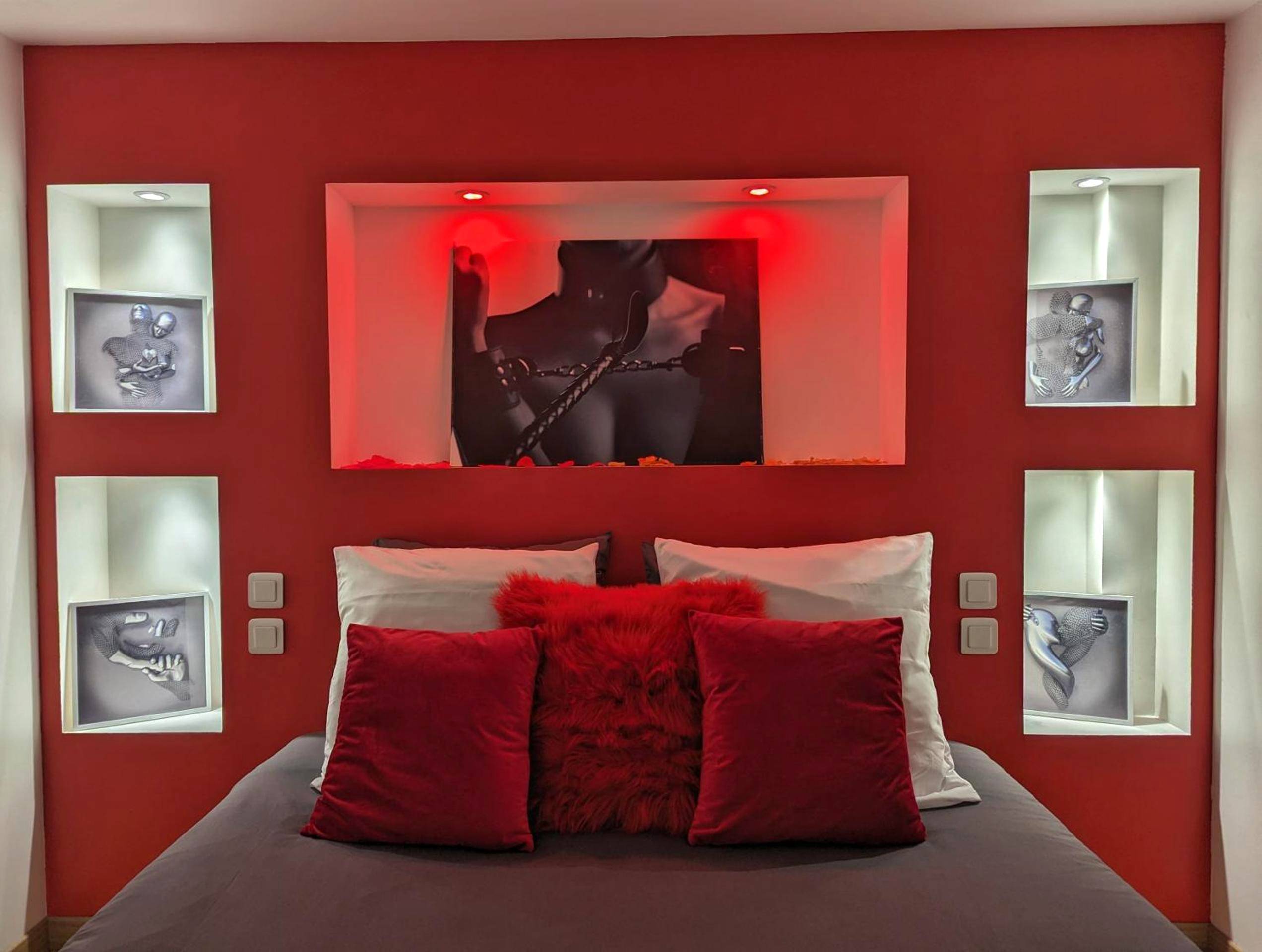 Lit double avec coussins rouges et cadres érotiques - Dark Room Perpignan aux 50 nuances Jacuzzi Privé