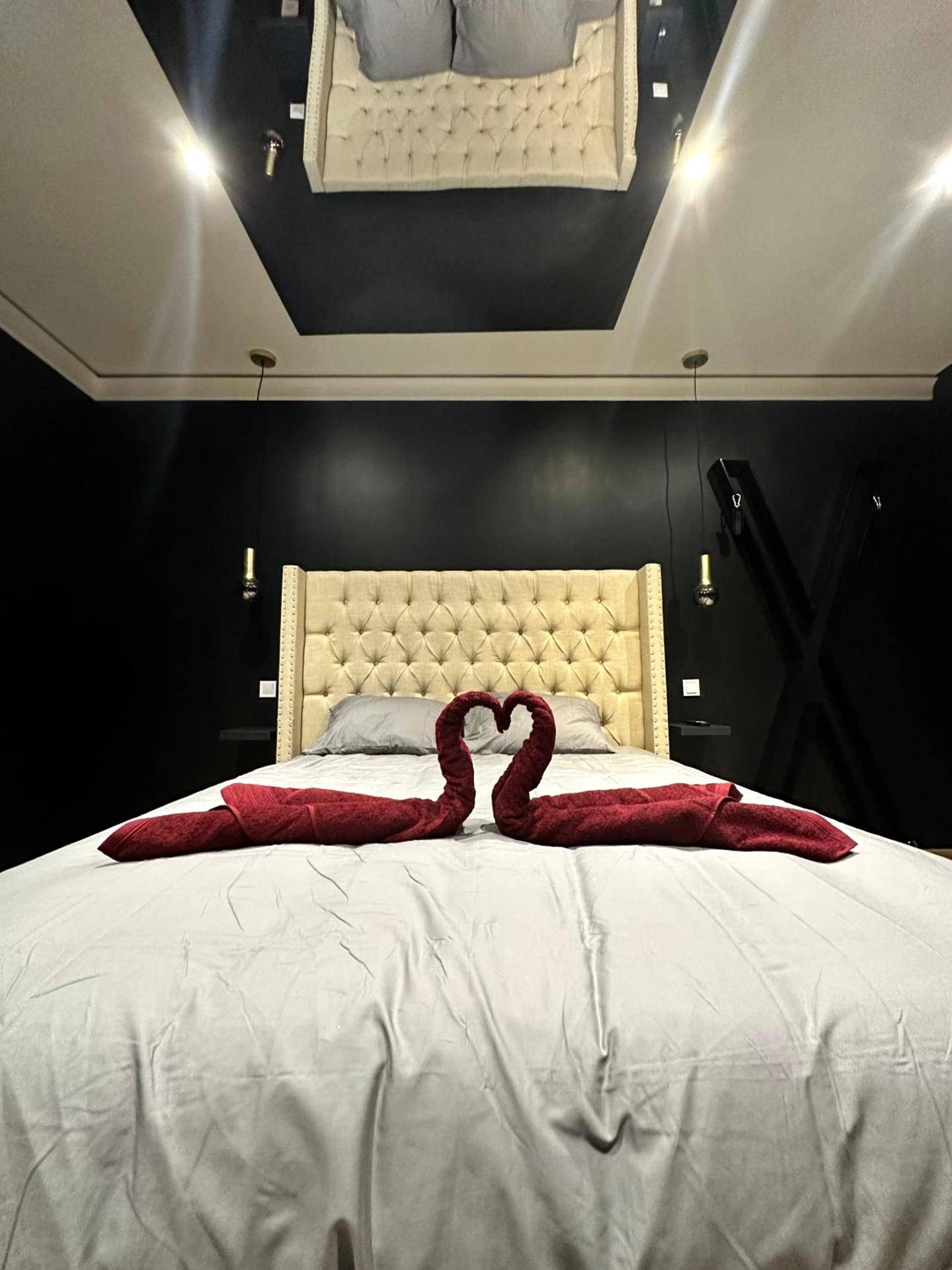 Lit avec cygnes en serviettes et miroir au plafond - Dark Room BLOIS - Love Room