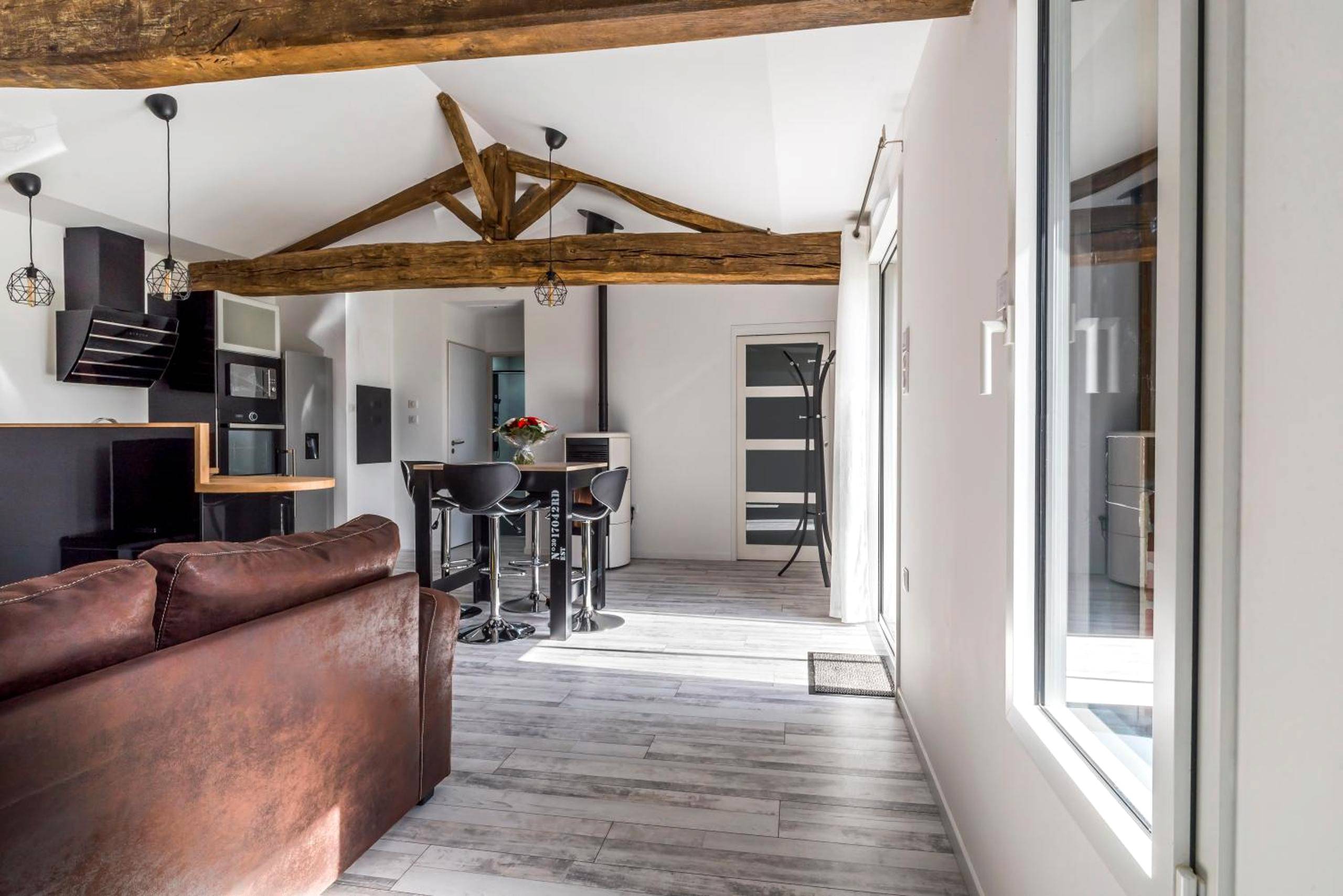 Pièce de vie lumineuse avec poutres apparentes - Gîte de la Daudière La Grange