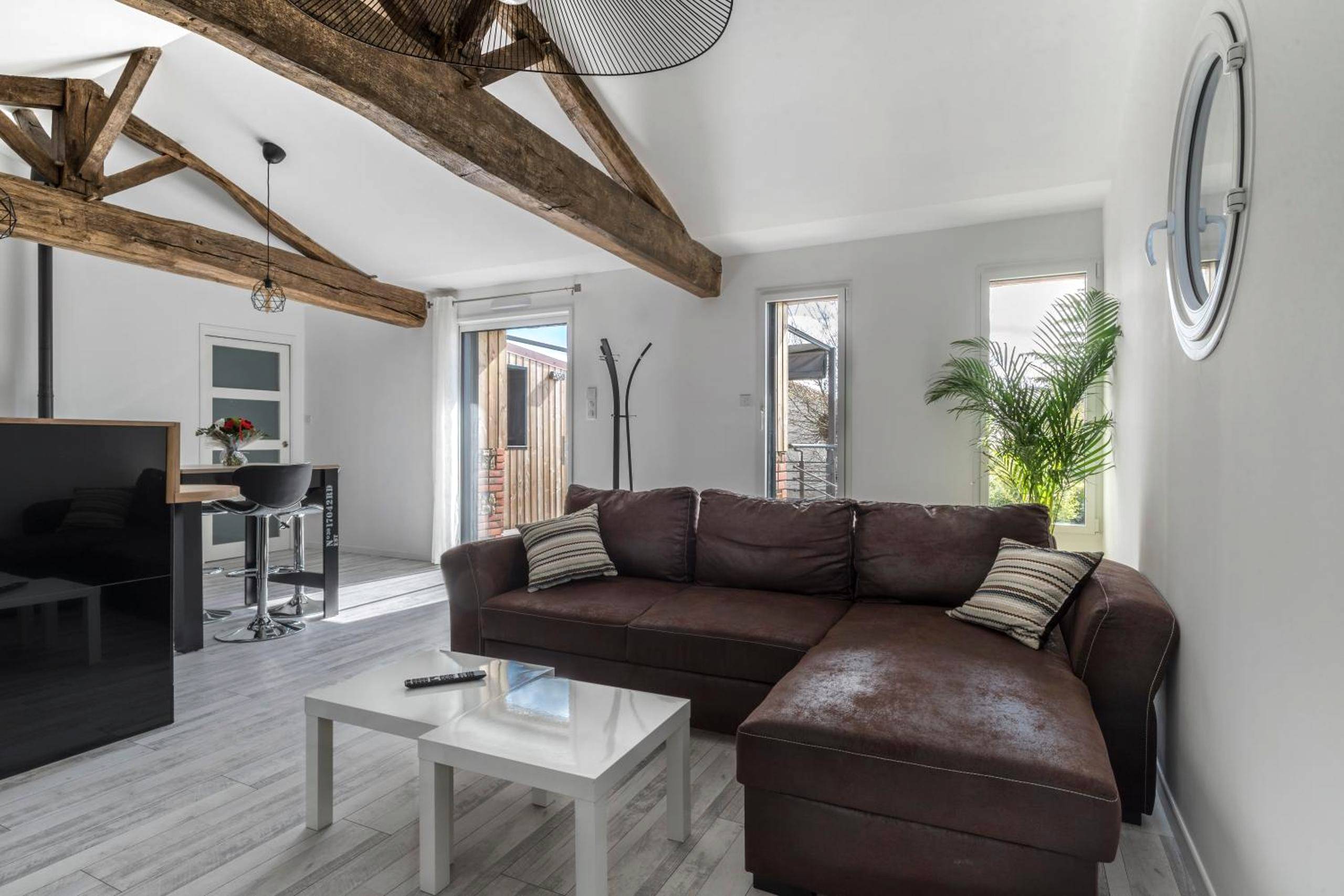 Salon avec canapé d'angle et table basse - Gîte de la Daudière La Grange