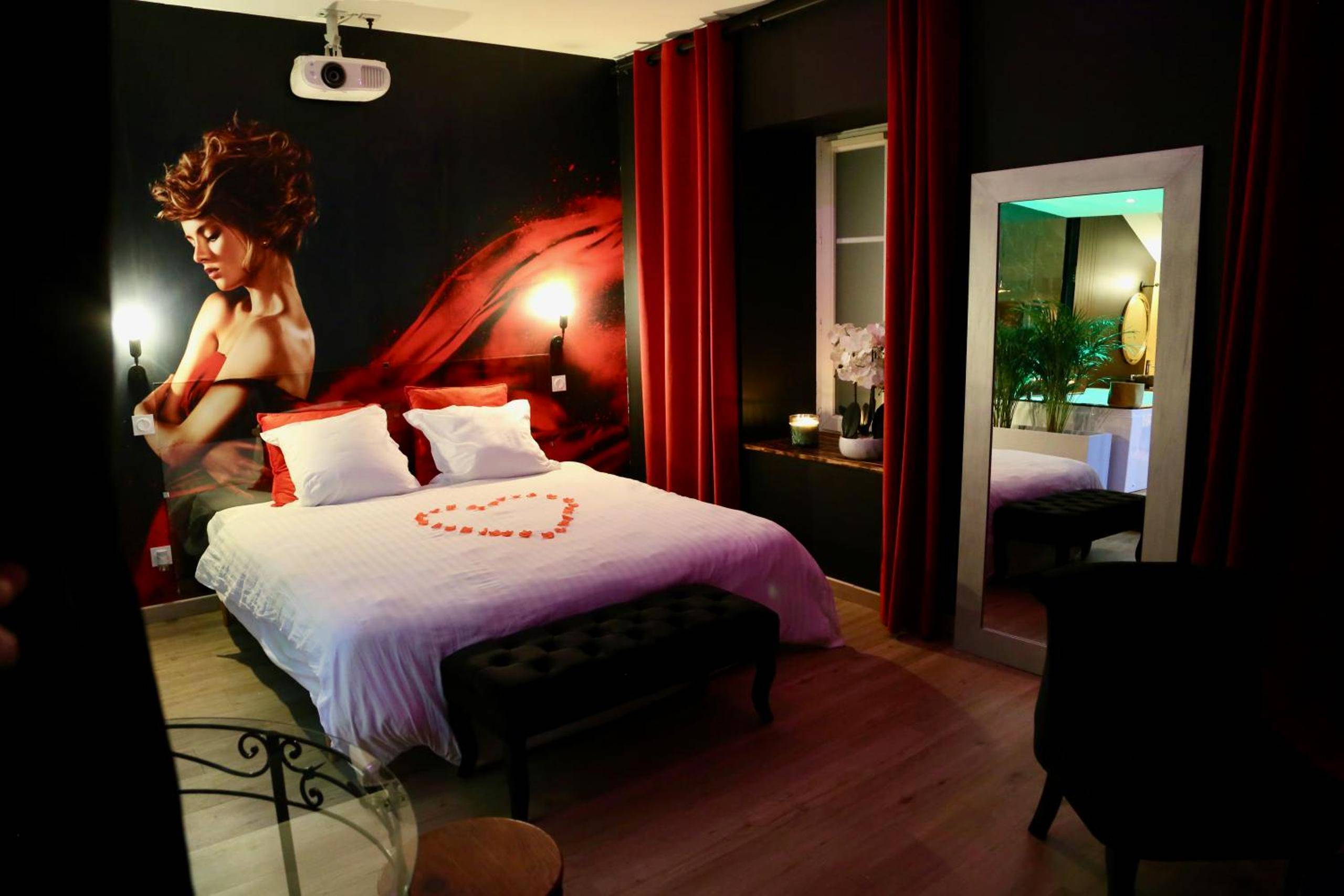 Chambre romantique avec pétales en cœur sur le lit - love room gold - les delices rooms