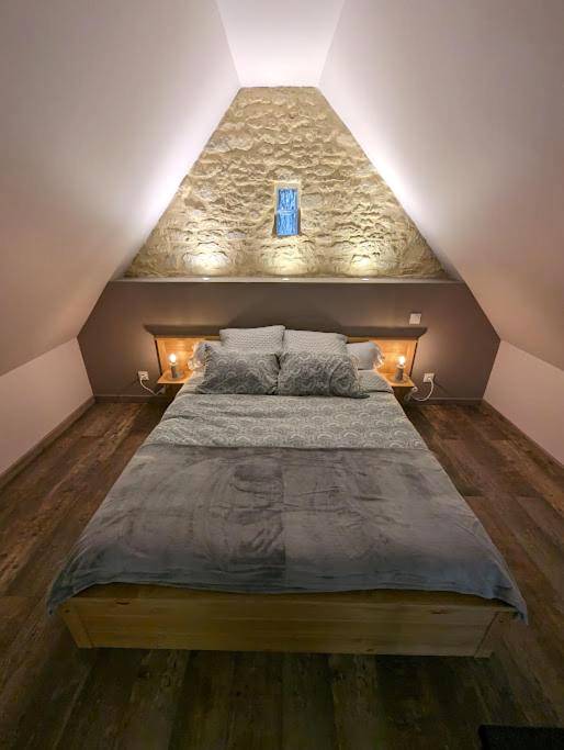 Chambre sous combles avec mur en pierre éclairé - Déliv'Love