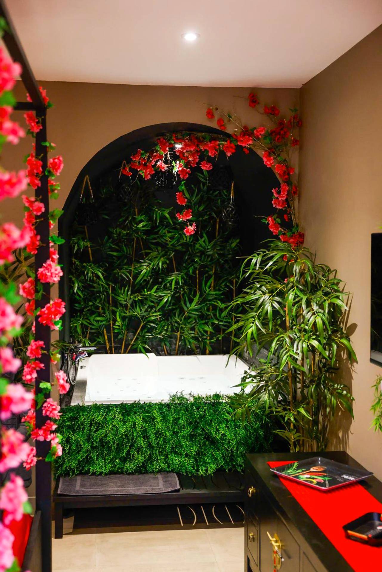 Baignoire balnéo entourée de bambous et fleurs - la demeure de POULPICAN Chambre SAKURA jacuzzi charme romantique...