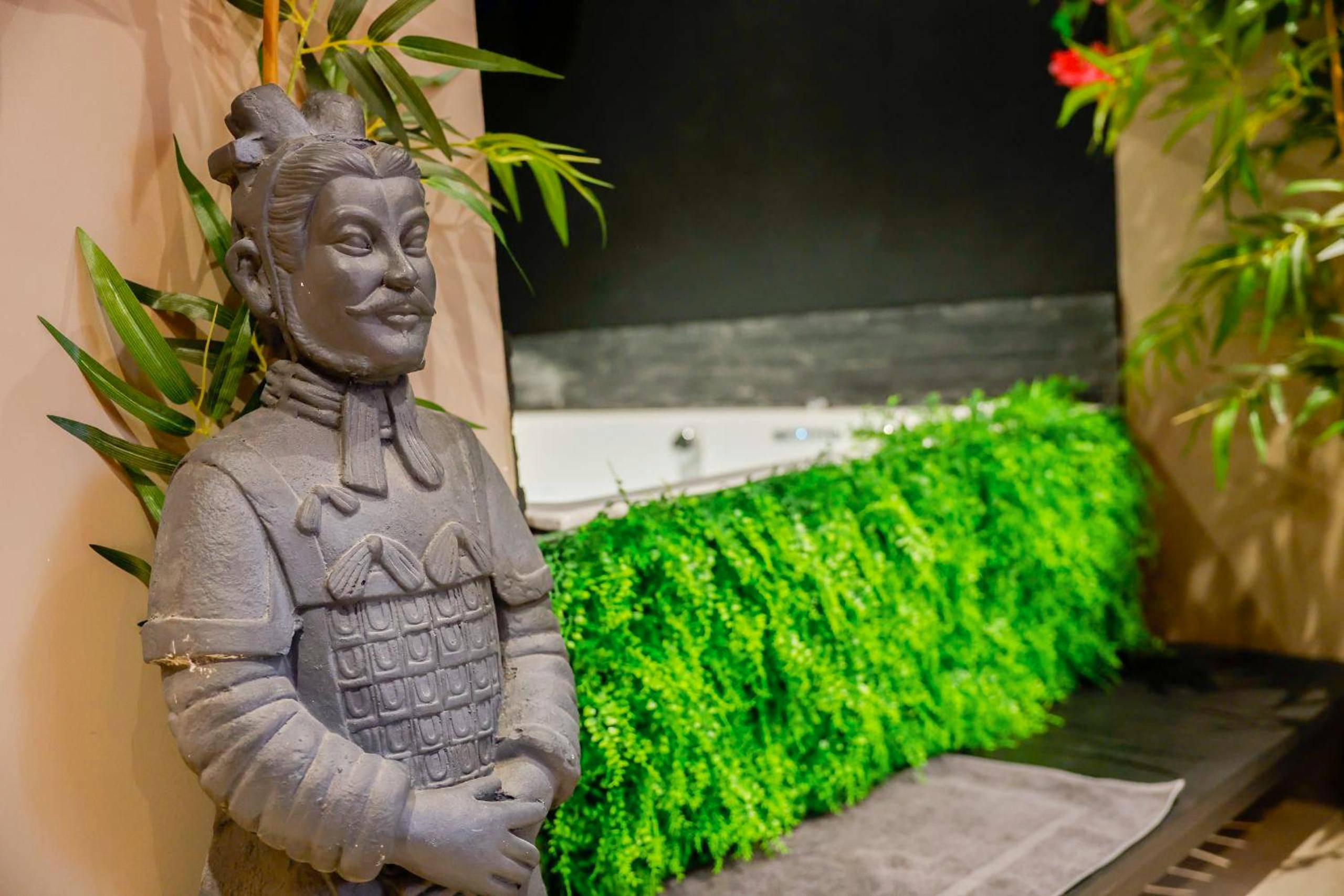 Statue de guerrier chinois et décor végétal - la demeure de POULPICAN Chambre SAKURA jacuzzi charme romantique terrasse...