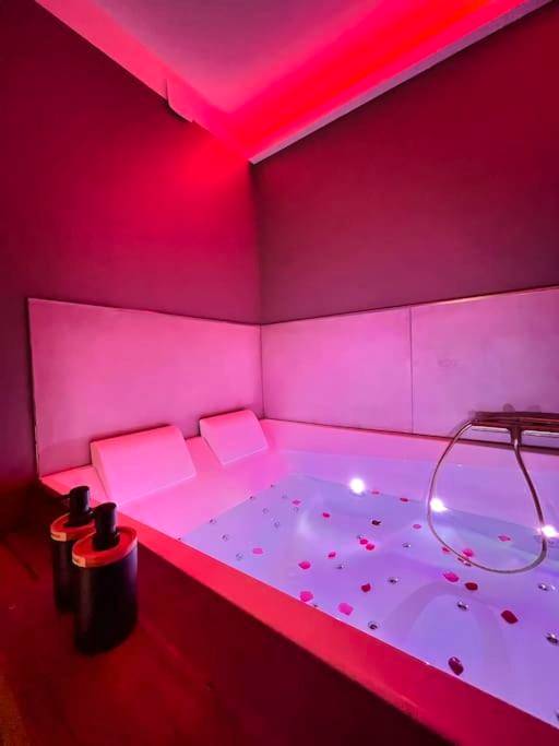 Baignoire balnéo avec pétales et néons roses - Le désir secret