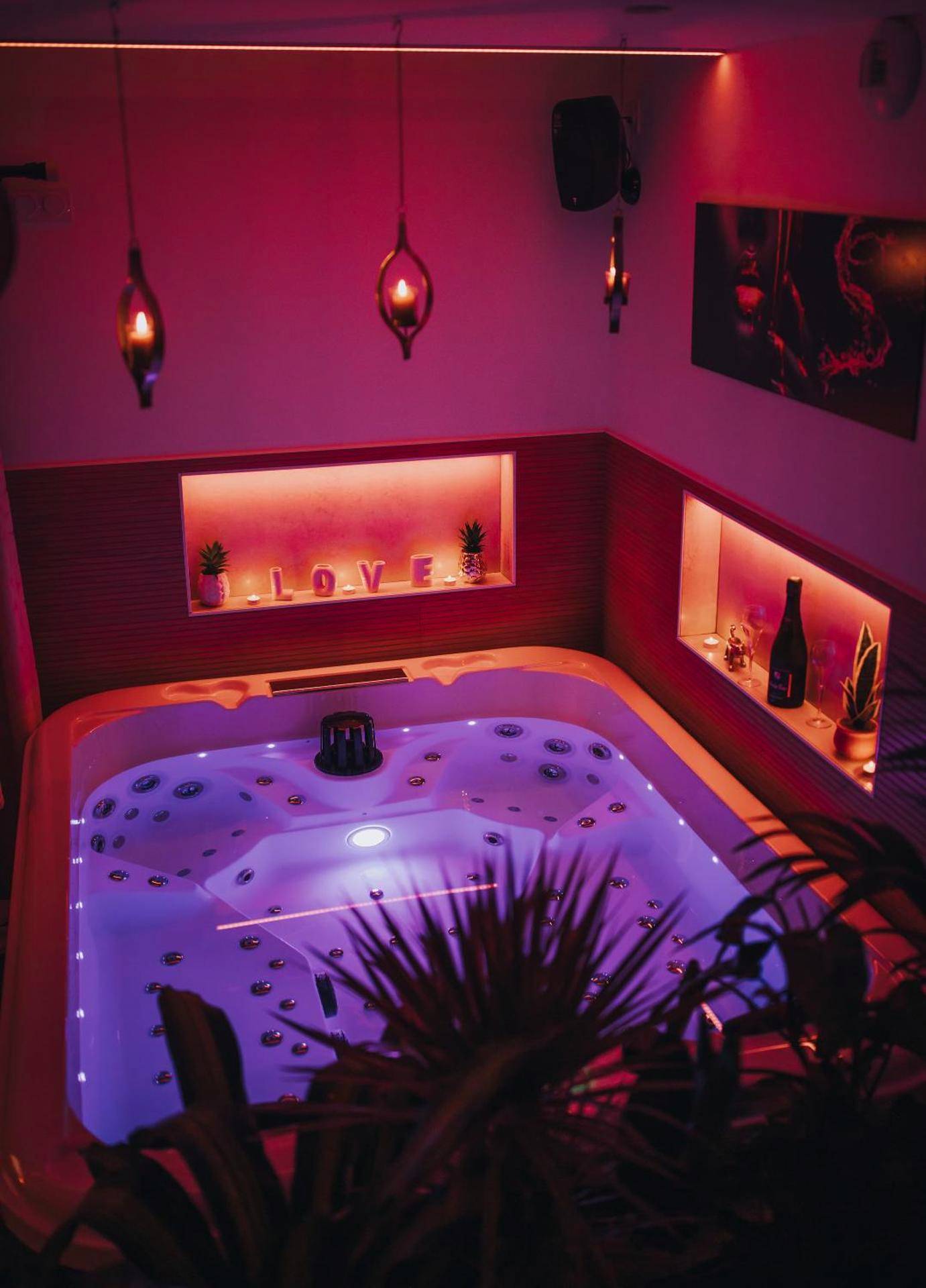 Jacuzzi privatif avec éclairage rose et néon LOVE - Love Room Camors - Le Desirella gite De Charme Spa